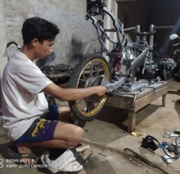 M. Ujang Ilham (pemilik bengkel Taruna Auto Motor) sedang mengerjakan kerangka motor di bengkelnya. (Dok. pribadi)