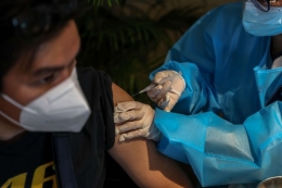 Vaksinator menyuntikkan vaksin AstraZeneca pada warga saat peresmian Sentra Vaksinasi COVID-19 di Rumah Sakit St. Carolus, Jakarta Pusat, Senin (14/6/2021).| Sumber: KOMPAS.com/GARRY LOTULUNG