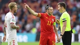 Gareth Bale memprotes wasit Daniel Siebert menyusul gol kedua Denmark, yang menurut Wales seharusnya dianulir karena melakukan pelanggaran terhadap Kieffer Moore (Foto: Getty Images via BBC Live)
