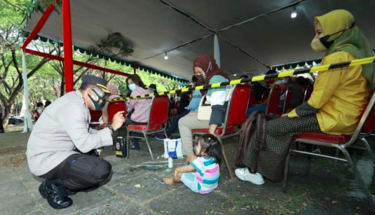 Foto : Kapolrestabes Surabaya saat menyapa anak kecil di sela sela acara serbuan vaksinasi nasional (Dokpri)