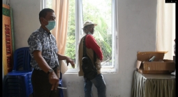 Arman (memakai topi) memeriksa kondisi jendela Puskesmas Bekawan. (Foto : Elvidayanty/dok.Dinkes Inhil) 