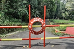 Akses jalan ke wilayah RT 01 dan RT 02 Dusun Randu, Desa Hargobinangun, Kecamatan Pakem, Kabupaten Sleman ditutup dan ditulisi lock down. (Foto: KOMPAS.COM/YUSTINUS WIJAYA KUSUMA) 