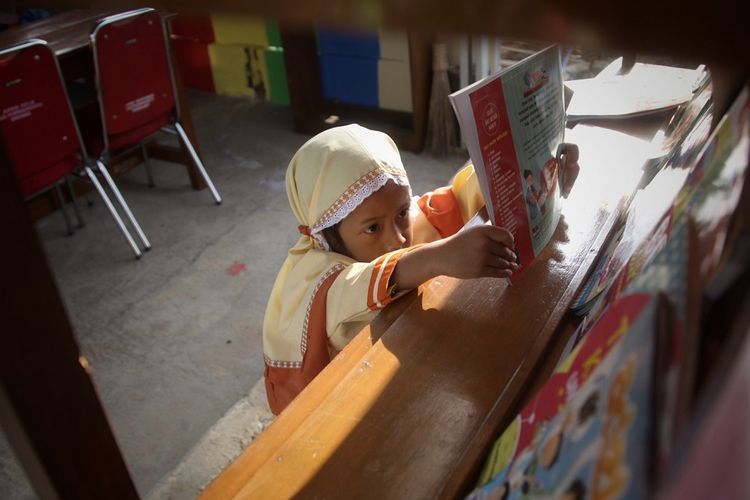seorang anak sedang mengembalikan buku bacaannya (sumber : kompas)