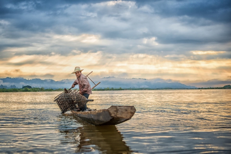 Seorang nelayan sedang memasang perangkap ikan (Pixabay.com)