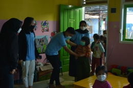 Foto Tim KKN UM menerapkan protokol kesehatan terhadap anak-anak Desa Gunungronggo sebelum acara penyuluhan mitigasi bencana