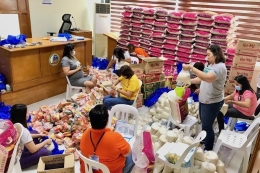 Pekerja sosial memasukkan bahan bantuan sebelum didistribusikan ke warga di wilayah Rizal. - Sumber: Rappler