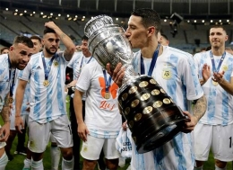Angel Di Maria, Winger Argentina sekaligus pencetak gol yang membawa Aregntina juara sedang mencium trofi juara Copa America 2021.| Sumber: sports.sindonews.com
