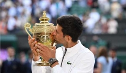 Novak Djokovics mencium trophy Wimbledon, 14 Juli 2019(beritasatu.com)