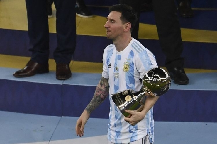 Lionel Messi memegang trofi Top Skor Copa America 2021 setelah timnas Argentina mengalahkan Brasil 1-0 di final yang bergulir di Stadion Maracana pada Minggu (11/7/2021), pagi hari WIB.| Sumber: MAURO PIMENTEL via Kompas.com