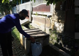Mahasiswa KKN Tematik UM mengambil sampah organik yang sudah dipilah ke setiap rumah warga (dokpri)