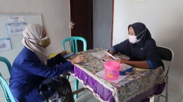 Mahasiswa memberikan pendampingan kepada salah satu perawat Polindes dalam mengakses video sosialisasi - Dok. KKN Purwosekar