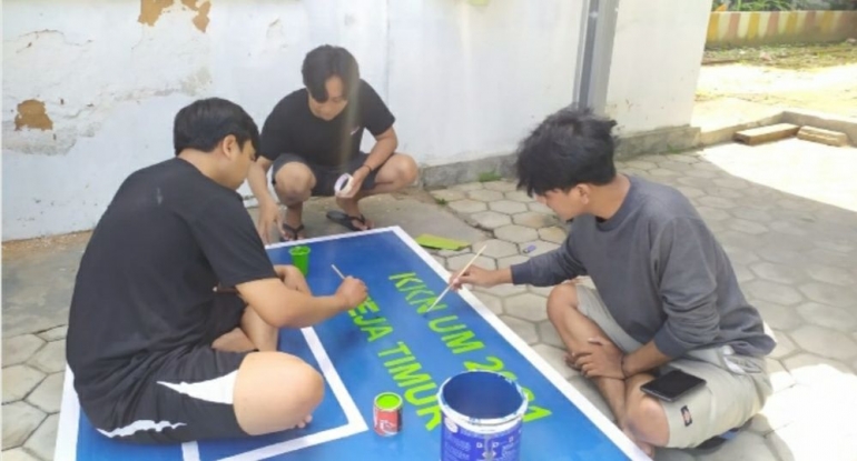 Proses pengecatan papan pantul yang dilakukan oleh Mahasiswa KKN UM