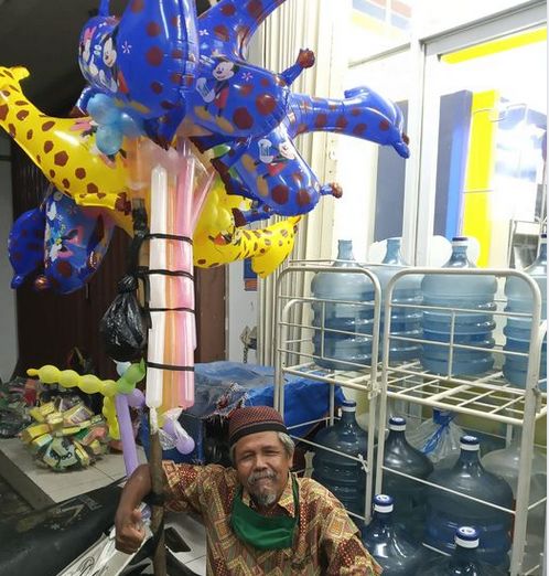 Pak Pi'i penjaja balon keliling di kawasan Grand Depok City. (Foto: Norman Meoko)