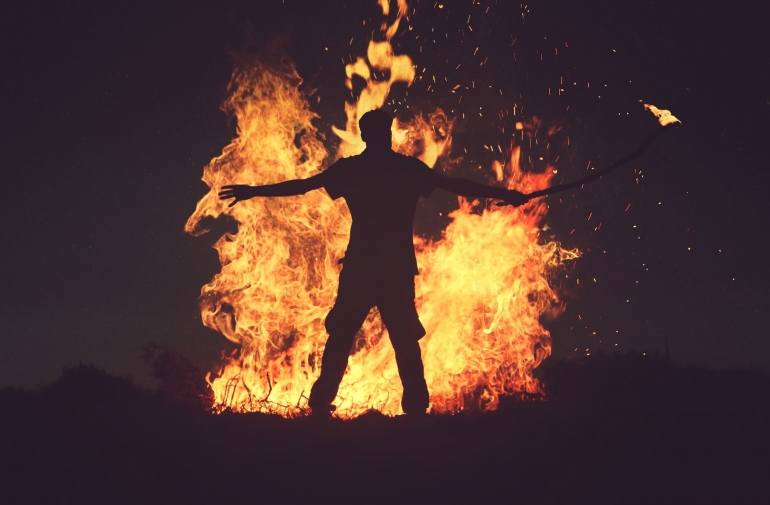 Ilustrasi seorang pria berdiri di depan kobaran api (Foto: StockSnap Via Pixabay)