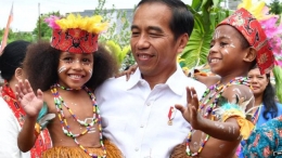 Deskripsi : Anak-anak Papua sedang bermain dengan bapak presiden Joko Widodo, Sumber : Kumparan.com