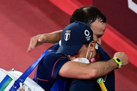 Kevin Cordon memeluk sang pelatih saat memastikan diri lolos ke semifinal usai mengalahkan pebulutangkis Korea di Olimpiade 2020. (kompas.com)