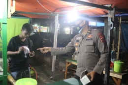 Personel Polda Banten saat memberikan masker kepada salah seorang pelanggar prokes, (dok. Humas Pandeglang)