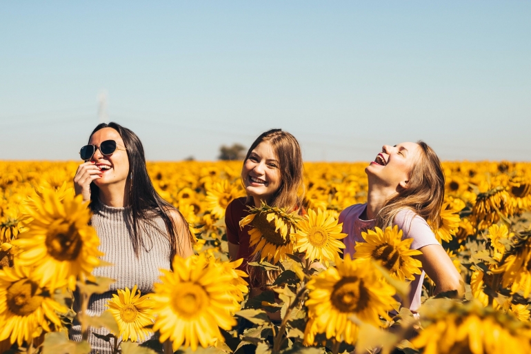 unsplash/Antonino Visalli (Tiga orang gadis yang terlihat begitu bahagia di taman bunga matahari)