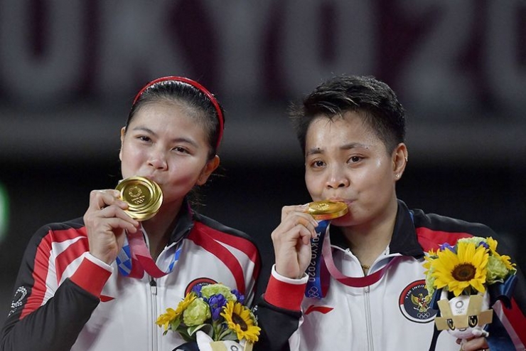 Pasangan  ganda putri Greysia/Apriyani mengecup medali emas  yang diraihnya di Olimpiade Tokyo (sumber : kompas.com)