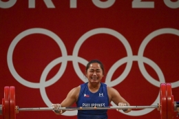 Lifter Filipina Hidilyn Diaz berhasil meraih emas di kelas 55 kg angkat besi putri Olimpiade Tokyo 2020. Senin (26/7/2021).(AFP/VINCENZO PINTO dipublikasikan Kompas.com)