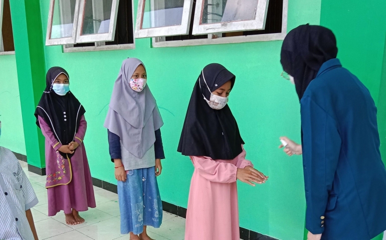 Mahasiswa dan peserta sosialisasi memakai hand sanitizer sebelum memasuki ruangan (Dokpri)