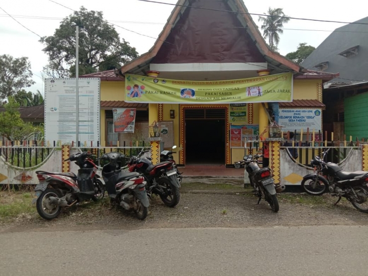 Gambar I Pemasangan Spanduk himbauan menerapkan Protokol Kesehatan di Balai Desa Faekhu