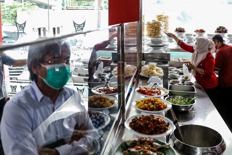 Pelayan mengenakan masker dan pelindung wajah saat mempersiapkan pesanan makanan di Restoran Sederhana, Bendungan Hilir, Jakarta Pusat, Senin (8/6/2020) | Sumber: KOMPAS.com/GARRY LOTULUNG
