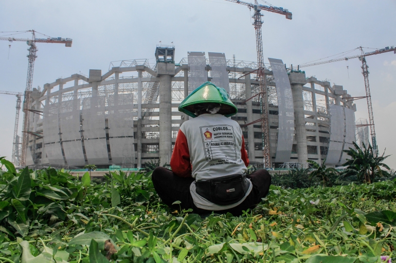 Tampak belakang aktivitas petani menanam sayur-sayuran di tengah pembangunan Jakarta International Stadium (JIS). (Jonas/Mahasiswa)