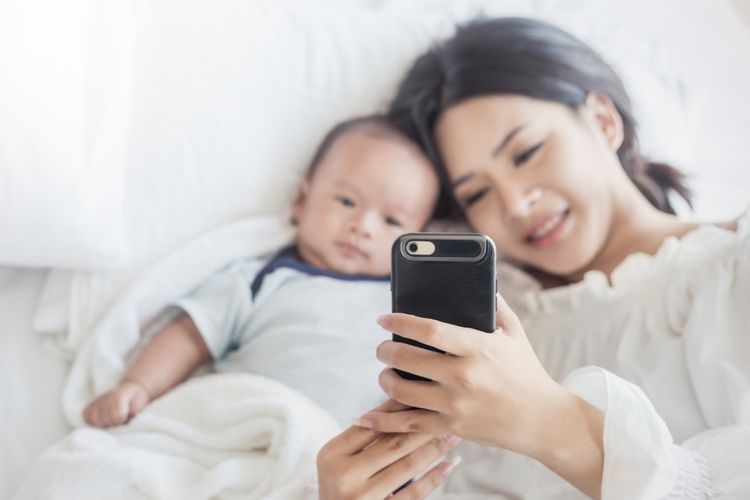 Ilustrasi ibu menggunakan handphone di dekat anak | Sumber: shutterstock lifestyle.kompas.com