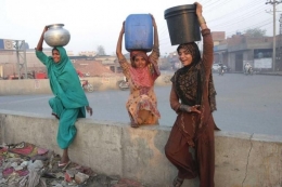 Perempuan Pakistan membawa air di sebuah tempat pemukiman kumuh di kota Lahore, Pakistan. | Sumber: www.abc.net.au/news