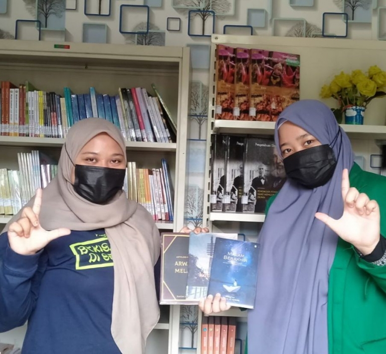 Mahasiswa Universitas Andalas Padang Wardatul Aqliyah (kanan) bersedekah buku di Perpusdes Karya Makmur (dokpri)