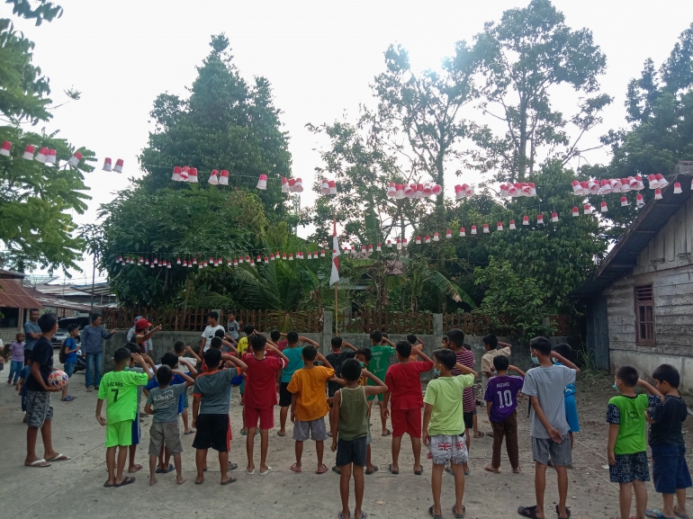 Anak-anak serentak hormat ke tiang bendera merah putih di Kelurahan Kampung Pondok, kota Pariaman, Sumatera Barat. (Farhan Olivio/Mahasiswa)