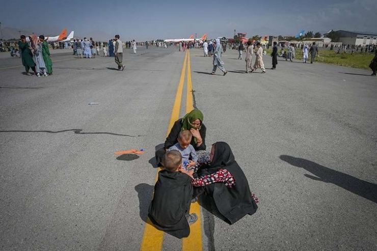 Orang-orang menunggu untuk dapat diberangkatkan dengan pesawat saat mereka berebut untuk melarikan diri ke luar negeri, di Bandara Kabul, Afghanistan, Senin (16/8/2021). Foto: AFP/WAKIL KOHSAR via KOMPAS.com