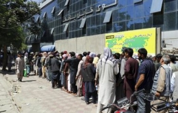 Warga Afghanistan menunggu di depan Kabul Bank, di Kabul, Afghanistan, Rabu, 25 Agustus 2021.(AP via Kompas)