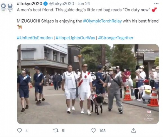 Sumber : www.twitter/Tokyo2020.com. Seekor Labrador, memandu tuannya memakai kacama hitam, ikut parade #OlympicTorchRelay. Si Labrador, sedang bertugas, sesuai dengan tugasnya sebagai anjing pemandu .....