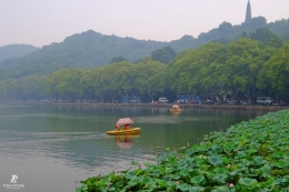 Sepasang kekasih berperahu di Danau Barat dgn latar belakang Pagoda Baochu di sebelah kanan atas. Sumber: Dokumentasi pribadi