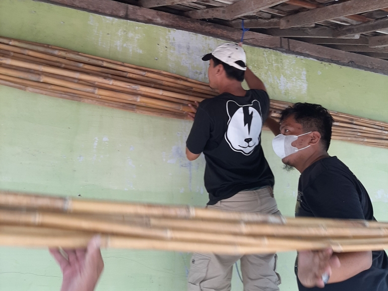 Mahasiswa KKN membantu merapikan kayu tiang bendera