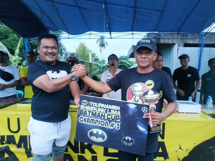 Pelatih Markas Batman FC Malik Baba menerima trofi dan bonus juara