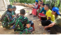 Anggota Satgas TMMD Ke-112 dari TNI-AL sedang berbincang-bincang dengan warga. (Dokpri)