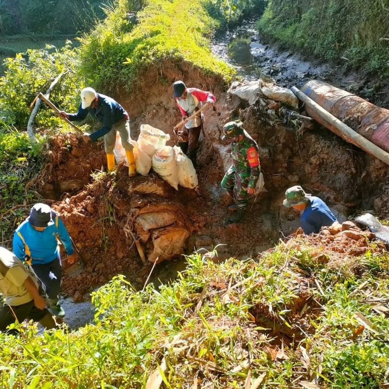 Warga bahu membuat tanggul irigasi dengan babinsa