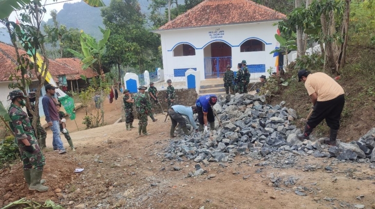 Warga di lokasi TMMD sedang bantu memecah batu, untuk pengerasan jalan/dokpri