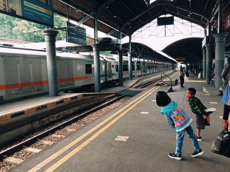 Dua anak kecil melongok ke arah datangnya Kereta Api Sri Tanjung yang akan membawa mereka ke Stasiun Lempuyangan Yogyakarta dari Stasiun Surabaya Gubeng sebelum larangan perjalanan kereta api. - Dokumen Pribadi