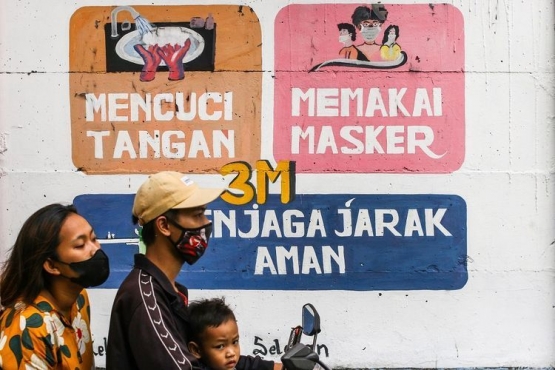 Pengendara melintas di dekat mural bertemakan COVID-19 di Petamburan, Jakarta, Rabu (21/7/2021).  (ANTARA FOTO/Rivan Awal Lingga via kompas.com)