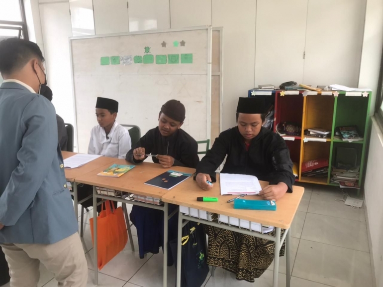 (gambar 2 : Mahasiswa sedang mengajar pada salah satu mata pelajaran di SMP Tahfidz Al-Hidayah)
