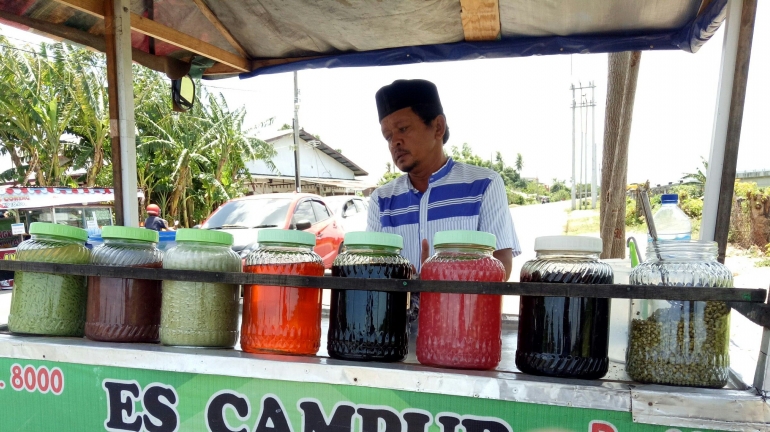 Rusli dengan becak dagangan es campur sedang menunggu pembeli (Dokpri)