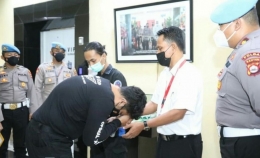 Brigadir Polisi berinisial NP mencium tangan orangtua FA, setelah mengungkapkan permintaan maaf. Foto: Dokumen Polda Banten