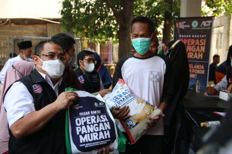 Presiden ACT Ibnu Khajar (kiri) saat memberikan paket sembako dalam Operasi Pangan Murah. (ACTNews/Abdurrahman Rabbani)