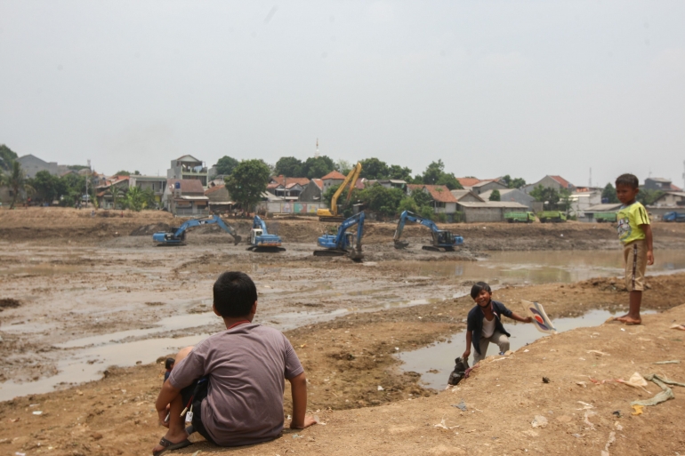 Anak-anak bermain di tepi proyek pengerukan lumpur Waduk Munjul, Jalan Wijayakusuma RW 04, Kelurahan Munjul, Kecamatan Cipayung, Jakarta Timur