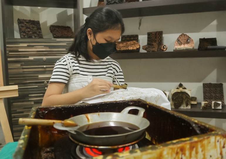 Salah satu pengunjung membuat batik dengan teknik canting tulis. (Foto : Eva Setiya)