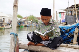 Seorang Santri Sedang Membaca Al-Qur'an baru bantuan dari ACT. (foto: ACTNews)